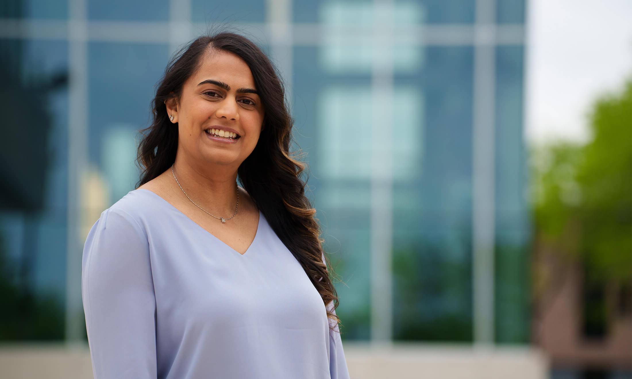 An image of Divyani Patel outside a building.